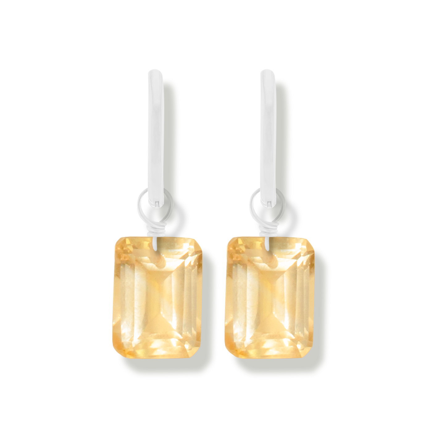 pair of silver earrings with citrine marquise cut gemstones on a white background.