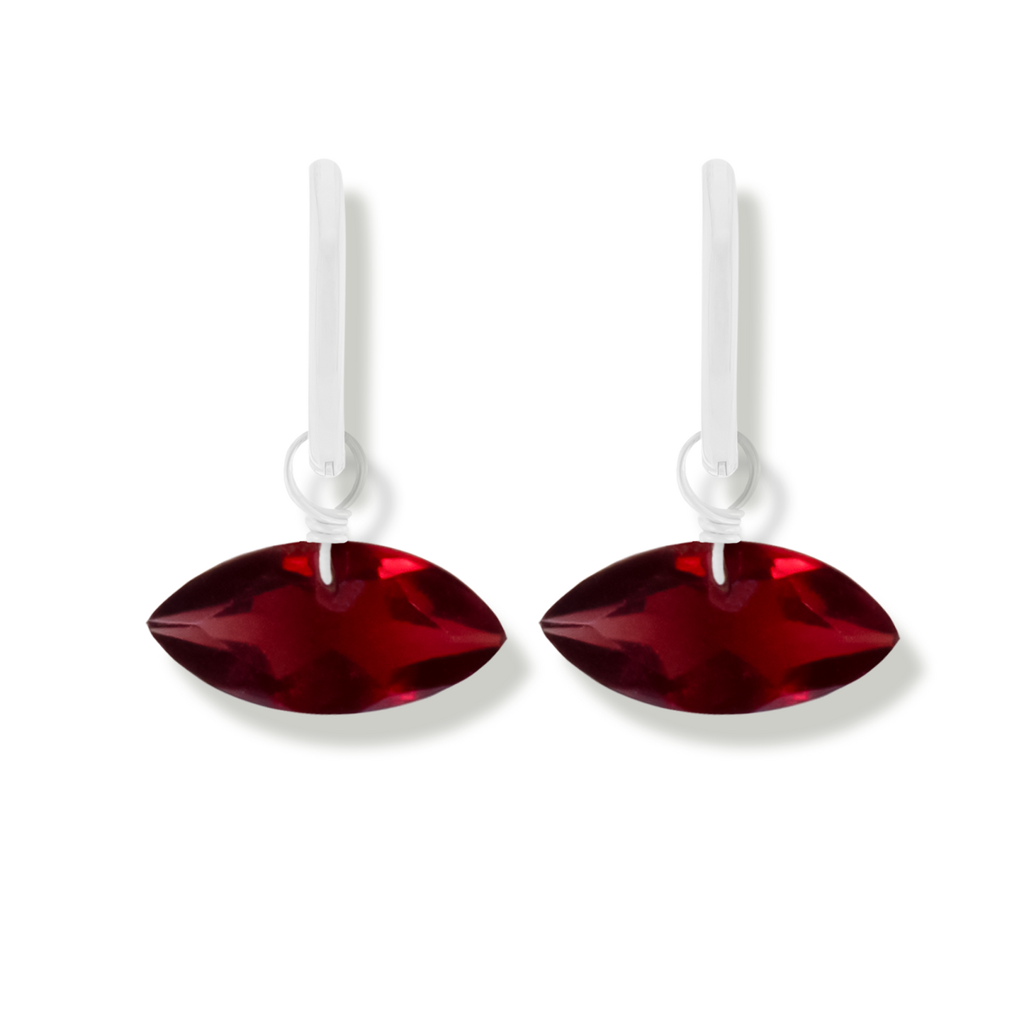 pair of silver earrings with garnet marquise cut gemstones on a white background.