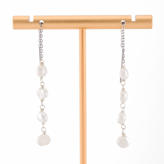 baroque pearls on silver threader earrings on a white background.