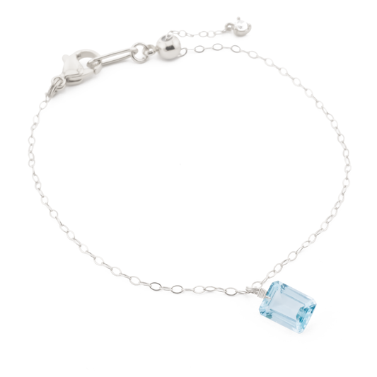 sterling silver dainty chain bracelet with blue topaz gemstone charm.
