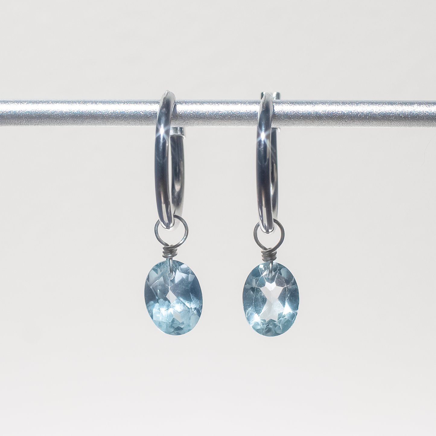 Blue Topaz Oval Cut Rhodium Hoop Earrings