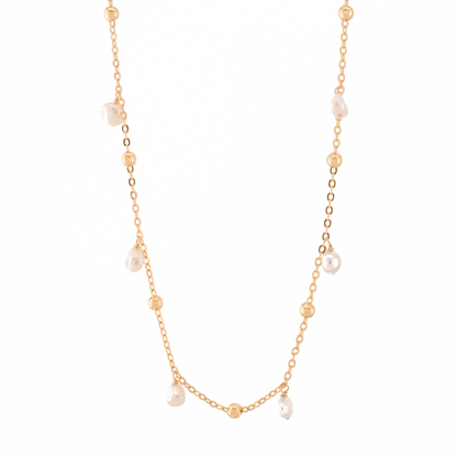 gold necklace with gold beads and baroque pearls on a white background.