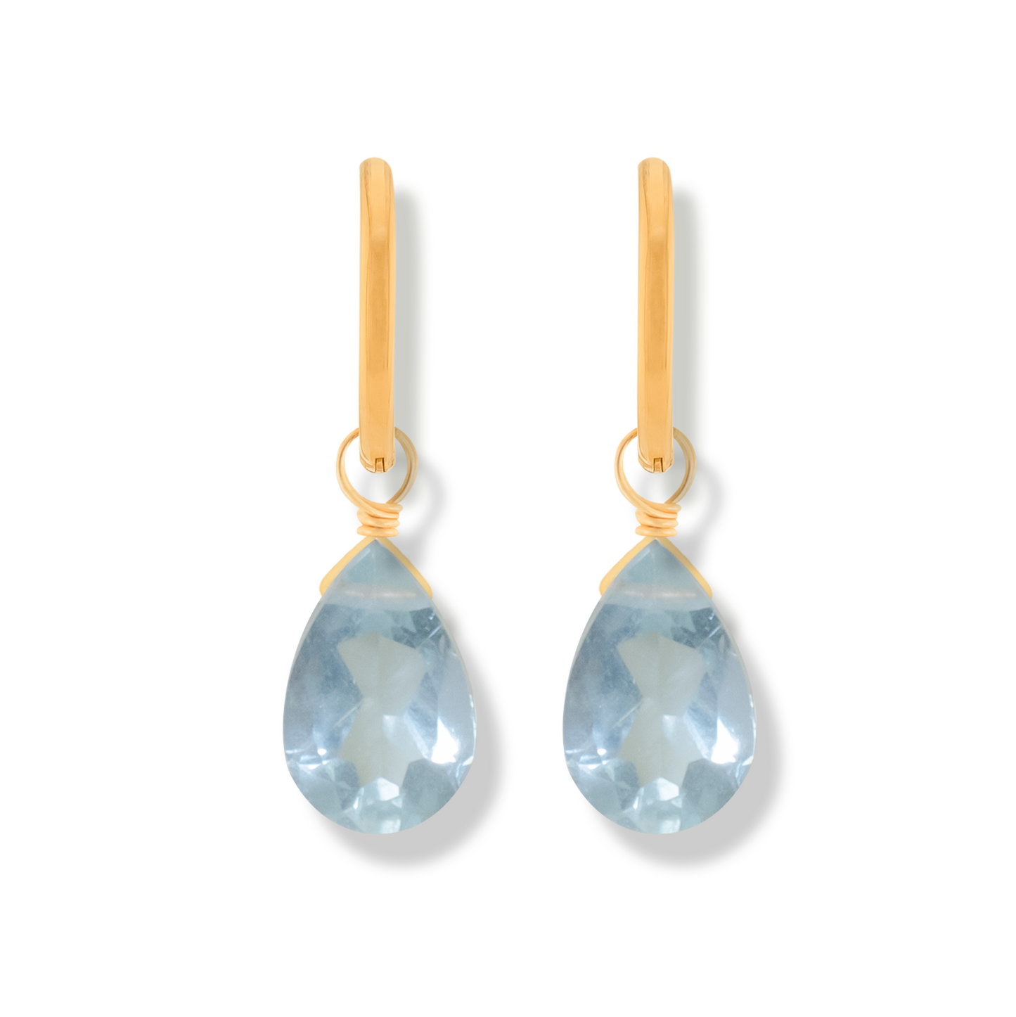 Pair of 14k gold-filled hoop earrings with blue topaz pear cut gemstones on a white background