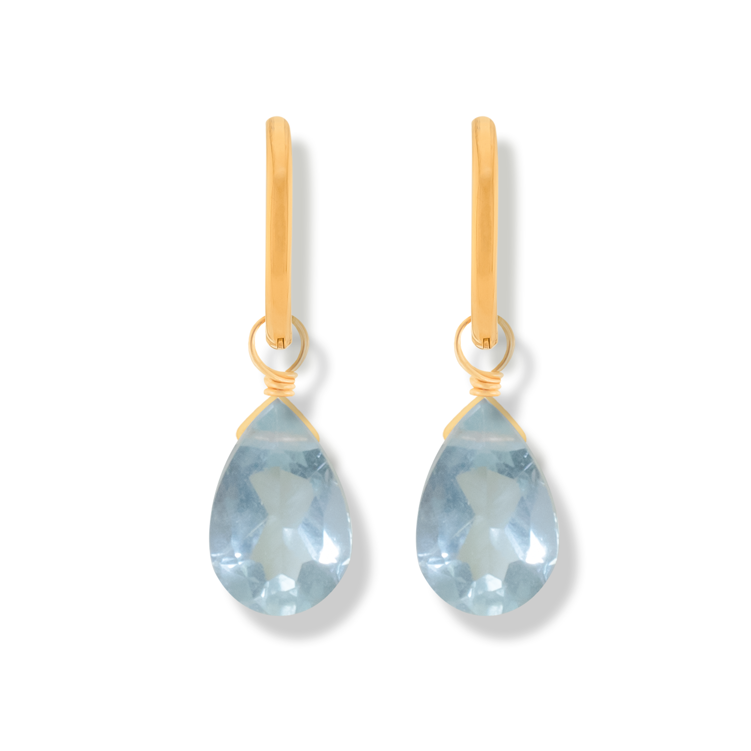Pair of 14k gold-filled hoop earrings with blue topaz pear cut gemstones on a white background