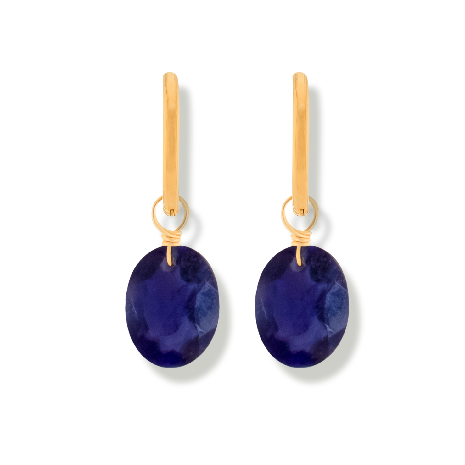 Pair of earrings with iolite oval cut gemstones and 14k gold-filled hoops on a white background